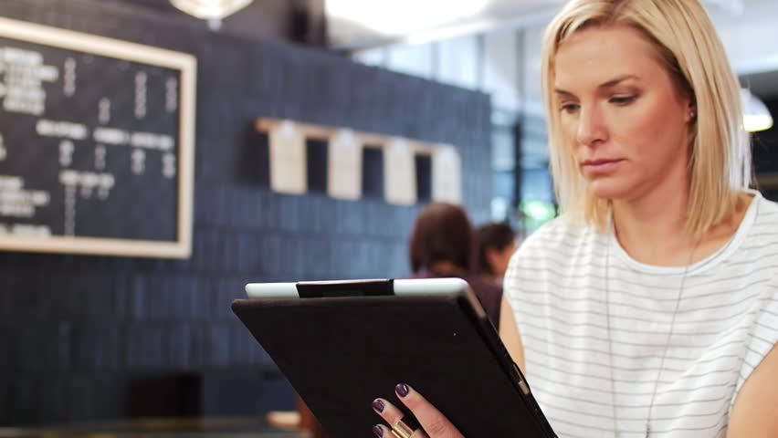 Picture of woman in the airport working on a tablet